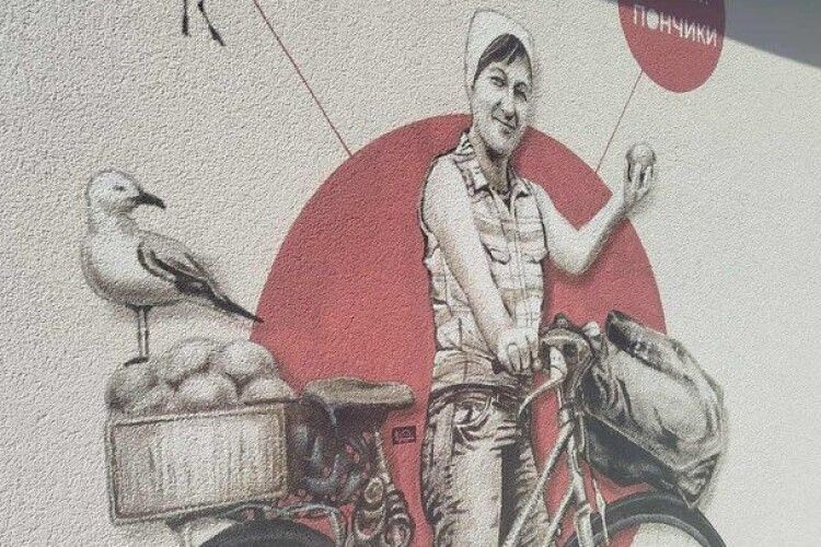 Жінка стоїть з велосипедом і гукає: «Свіжі пончики!» - на Світязі з'явився мурал Юрія Чайки