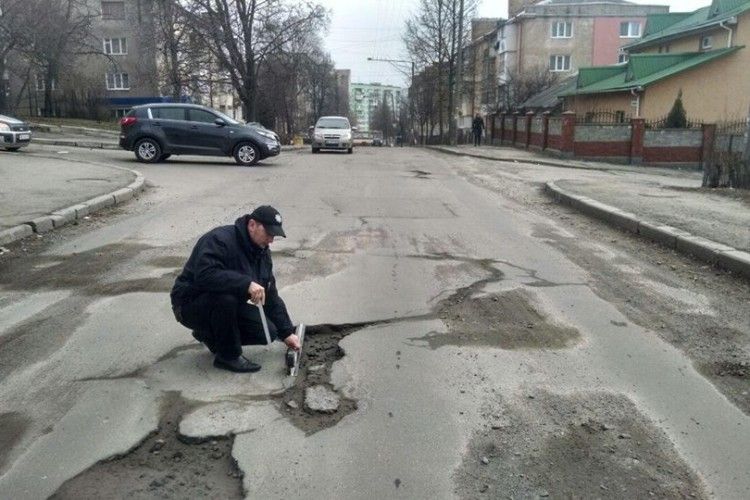 Хто – куди, а рівненські патрульні – міряти глибину ям на дорогах (фото)