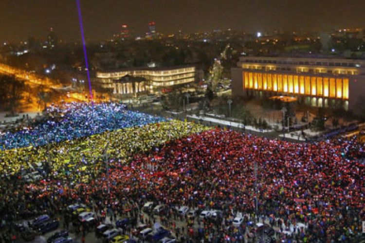 Протестувальники в Румунії розгорнули перед будівлею уряду «живий» прапор
