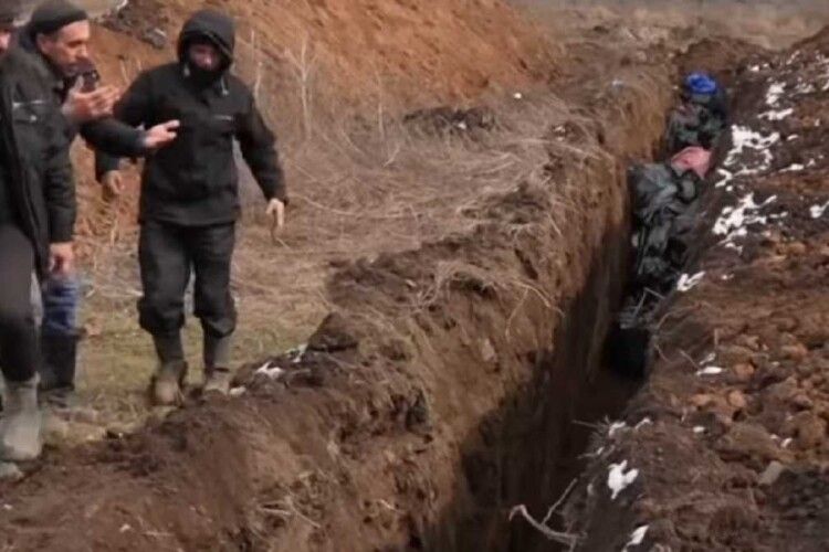 Геноцид. Опублікували страшні кадри поховання комунальниками мирного населення (Відео 18+)