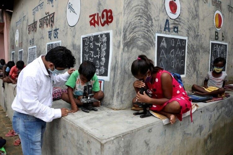 Замість шкільної дошки ㅡ стіни будинків: в Індії вчитель просто на вулиці проводить уроки