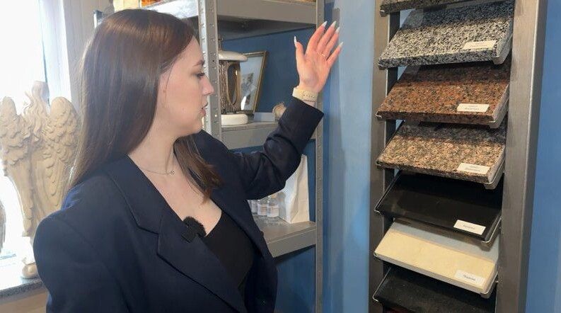 Менеджерка показує матеріал, з якого найчастіше замовляють пам’ятники. 