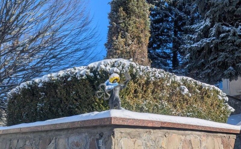 Кликун у зимовій шапці і шарфі.