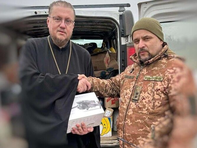 Тисне руку священнослужителю командир одного з батальйонів 100-ї бригади тероборони підполковник Олег Матвійчук.