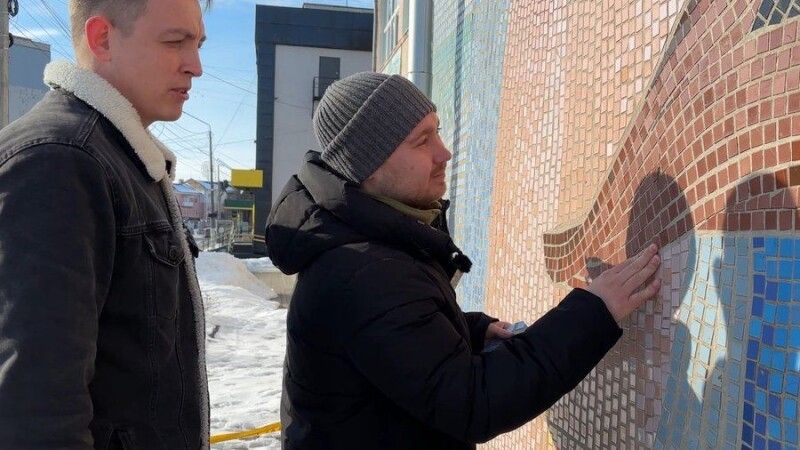 Історик Юрій Велінець та художник Павло Шачко оглядають мозаїку.