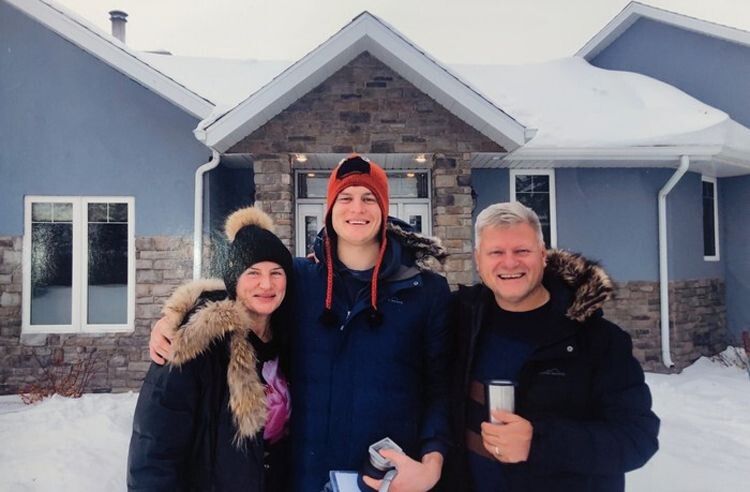Григорій з батьками біля будиночка родини в Канаді.