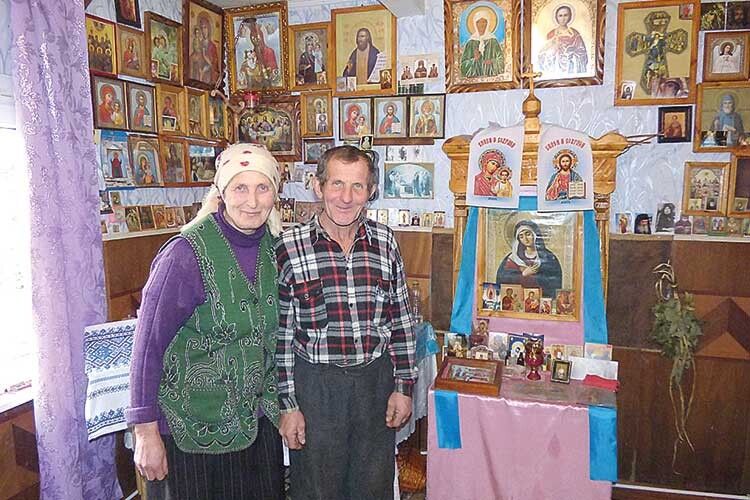 Подружжя Салівончиків у своїй Божій кімнаті  з домашнім іконостасом.