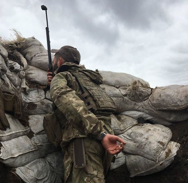 Український морський піхотинець біля села Водяне спостерігає в перископ за противником.