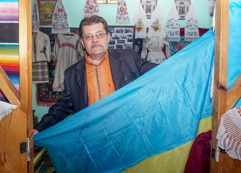Директор Ярослав Матящук гордо розгортає фронтового прапора, подарованого шкільному музею.